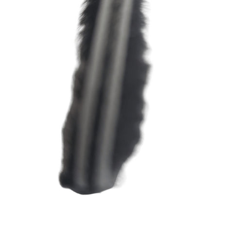 Close-up of a black eyelash extension on a white background